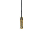 A closed brass Arcan Box pendant with intricate geometric engravings, hanging from a black cord against a white background.