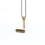 A close-up of the brass Arcan Box pendant in an open state, showcasing its hidden compartment and detailed screw mechanism.