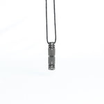 A straight-on view of the pendant hanging from its cord, highlighting the symmetry and mechanical precision of the design.