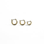 Three brass bio-organic septum rings with intricate carvings displayed on a white background. The rings have a clicker closure for easy wear and come in sizes 6mm, 8mm, and 10mm inner diameter.