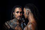 Two individuals with geometric tattoos are wearing GIGER Biomechanical Open Ended Hoop Ear Weights in silver by Kaya Movement. The intricate ear weights complement their bold tribal tattoos, blending futuristic and ancient aesthetics.