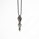 Intricate brass pendant with skeletal motifs and fluid lines, showcasing a sci-fi and dystopian design influence.