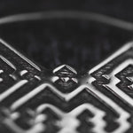 Close-up image of the AREVALO Shipibo Oversized Tribal Disc Hoop Earrings in Silver by Kaya Movement, showcasing intricate geometric patterns and textures with crisscrossing lines and curved shapes. The reflective surface of these 16-gauge silver brass earrings highlights the fine detailing and craftsmanship of the design.