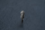 Against a dark grey textured background, the DIARA Biomechanical Clicker Hoop Septum Nose Ring in Silver by Kaya Movement stands upright, showcasing its polished surface and ribbed, leaf-shaped design. Reminiscent of 925 silver hoop body jewelry, its pattern resembles curved lines imitating the veins of a leaf.