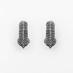 The MARVDASHT Medium Cyborg Clicker Ear Weights in 925 Silver by Kaya Movement showcase detailed engravings in a dark metallic finish, set against a clean white background. These dystopian pieces of body jewelry emphasize the intricate texture and structure of bird claws.