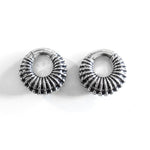 Introducing the TRILOBITE Large Biomechanical Clicker Ear Weights in Silver Brass by Kaya Movement. These 0 gauge earrings feature a round, ribbed, ridged texture with a polished metallic finish. Resembling post-apocalyptic body jewelry, they are elegantly displayed on a white background.