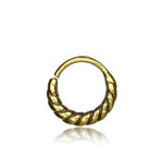 The TIARA Seamless Nose Ring in Gold from Kaya Movement features a textured, twisted design. With its open-end construction, it offers a seamless closure for easy wearing. Photographed on a plain white backdrop, the ring’s intricate detailing and shiny finish are highlighted beautifully.