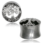 Two metallic double-flared ear plugs from Kaya Movement, the "Sacred Tree of Life Round Saddle Tunnels in Silver," feature an intricate Tree of Life design. The front view showcases the detailed tree etched into the silver metal, while the side view highlights the cylindrical shape and smooth surface of the gauged earplug, available in sizes ranging from 8mm to 16mm.