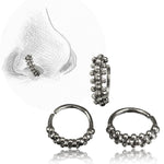A sketch of a nose with a close-up of the Kaya Movement ROE Beaded Nose Ring in Silver | 20 gauge. The image also shows three different views of the same metallic, textured ring—open, closed, and in profile—capturing its tribal ethnic design.