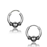 A pair of Kaya Movement's silver 925 Huggie Hoop Earrings, available in small or large sizes. Each earring features a central spherical bead with decorative ridges on either side. The hoops are open at the top, displaying where the ends meet. These tribal earrings have a reflective surface, giving them a shiny appearance.