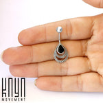 A hand is holding the IBOSA Teardrop Belly Piercing Ring in Silver & Black Mother of Pearl, featuring intricate detailing around the edges. The text "Kaya Movement" is displayed in the bottom left corner.