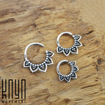 Three KAMAL Lotus Flower Rings in Silver (16 gauge) from Kaya Movement, featuring intricate designs with small circular beads and tribal ethnic lotus petal-shaped details, are displayed on a rustic wooden surface. The rings vary in size, from large to small. The logo "Kaya Movement" is visible in the bottom left corner.