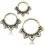 Three Kaya Movement ILA Seamless Septum Rings in Gold, 16 gauge with intricate designs are displayed. Each ring features a floral pattern reminiscent of a lotus flower, with dot details, showcasing a unique decorative style. These pieces of tribal ethnic body jewelry form a triangle shape in their arrangement.