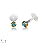 A pair of KEA Labret Stud earrings in small size feature natural turquoise stone centers, accented by gold-colored trim around the stones. The 16-gauge brass body jewelry is set against a white background with the text "Kaya Movement" in the bottom left corner.