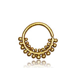 The ELE Seamless Ring in Gold from Kaya Movement features an intricate, beaded tribal ethnic design along the lower half of its circle. Crafted for easy use with an open clasp at the top, this 18-gauge piece is a versatile addition for multi-use piercings.