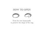 Instructional image on how to open a Kaya Movement ITA Seamless Ring in Silver | 16 gauge. The image shows two stages: a closed ring and a partially opened ring with a wire twisted horizontally. The text reads, "HOW TO OPEN" followed by "Twist the wire horizontally to preserve the shape of the ring.