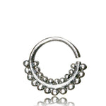 Introducing the ELE Seamless Ring in Silver by Kaya Movement. Crafted from 18 gauge silver, this circular earring features an open design. The lower half is adorned with small, round beads that create a decorative and textured look. Its reflective surface offers a shiny, polished appearance reminiscent of 925 silver body jewelry with a tribal ethnic design, all set against a white background.