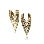 Introducing the IRA Chevron Ear Cuff in Gold by Kaya Movement: This set includes two gold-tone ear cuffs featuring a V-shaped design. One cuff sports smooth, plain V-bands, while the other boasts textured V-bands adorned with a pattern of small dots. Both open-backed and adjustable for easy attachment, these stunning cuffs are designed to fit comfortably on any ear.