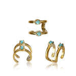 The LORY Ear Cuff in Gold & Turquoise from Kaya Movement is beautifully displayed on a white background. This minimalist collection features three distinct designs: a single band with two turquoise gemstones, a double band with two turquoise gemstones, and an elegant spiral design with two turquoise gemstones.