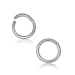 A pair of Kaya Movement's Silver septum clicker rings, crafted from 316L surgical steel, each featuring a polished finish and a small gap. Displayed against a white background, these versatile pieces are designed for various piercings such as daith, rook, helix, and cartilage. The tiny hoops are oriented to mirror each other perfectly.