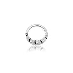 The LONA Silver Mandala-Style Septum by Kaya Movement exhibits a small, silver open hoop design featuring geometric faceted details and a subtle star motif. Its reflective surface creates a mirrored effect below. This celestial piece of nose, tragus, or lobe jewelry is showcased on a plain white background. Available in 6mm, 8mm, and 10mm diameters with a gauge of 1.2mm for those embracing the bohemian style.