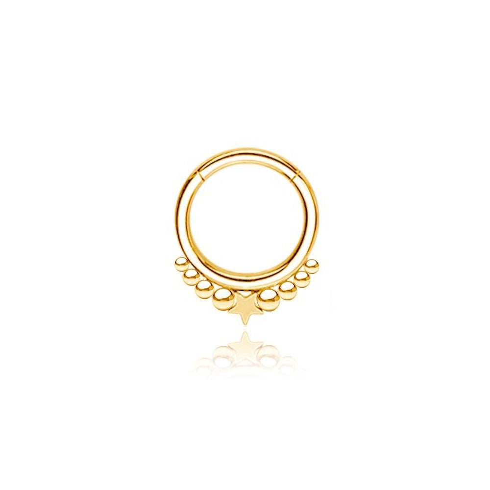 The Kaya Movement "Astria" Starry Bohemian Septum in 316L Gold PVD Steel features a gold circular hoop with a central star design. It includes progressively larger gold beads flanking the small star, creating a symmetrical celestial look. The earring has a Gold PVD finish and is displayed on a white background. This piece has an 8mm diameter and comes in a 1.2mm gauge.