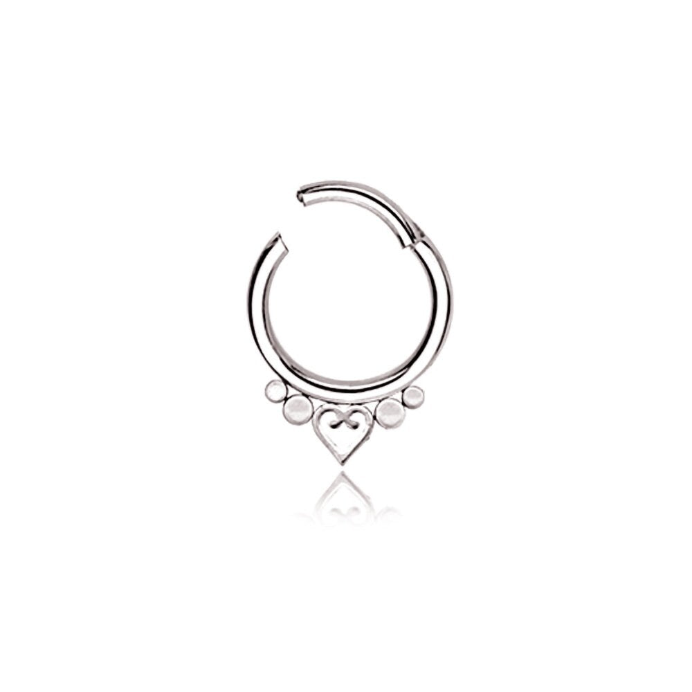 The Kaya Movement's Zuri Minimalist Mandala-Inspired Septum features a small, symmetrical heart in the center and is adorned with three evenly sized decorative silver beads on each side. This 1.2mm gauge and 8mm diameter piece of septum jewelry, crafted from 316L steel, boasts a sleek design and an easy-to-use clasp mechanism in a refined silver look.