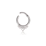 The Kaya Movement's Zuri Minimalist Mandala-Inspired Septum features a small, symmetrical heart in the center and is adorned with three evenly sized decorative silver beads on each side. This 1.2mm gauge and 8mm diameter piece of septum jewelry, crafted from 316L steel, boasts a sleek design and an easy-to-use clasp mechanism in a refined silver look.