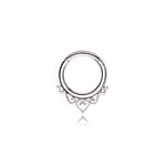 A minimalist septum ring from Kaya Movement, inspired by mandala designs and crafted from high-quality 316L steel, features a silver look under the name "Zura." The design showcases delicate heart detailing at the bottom and includes two small loops flanking the central heart, adding ornamental elegance to the piece. Available in 1.2mm gauge with diameters of 6mm, 8mm, or 10mm, this septum ring stands out against a white background for an eye-catching focal point.