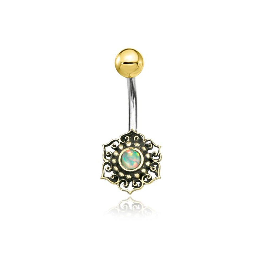 The Lutia Navel Jewelry by Kaya Movement is a boho-hippie festival accessory that features an exquisite mandala lotus design with a turquoise gem. This handcrafted belly button ring combines brass and surgical steel, showcasing a gold ball on one end and an intricate gold setting with a central turquoise stone on the other, all elegantly crafted on a curved silver bar.