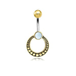 Introducing the Azmi Navel Jewelry by Kaya Movement, a striking piece from their Boho Ethnic collection. This unique handmade festival accessory features a curved surgical steel barbell with a gold-colored ball end. The lower end is beautifully adorned with a circular brass charm, detailed with intricate dots and centered around a white mother of pearl bead.