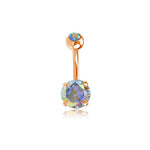 The Aurora Navel Jewelry by Kaya Movement showcases a simple, elegant design with a rose gold finish. Featuring a small iridescent gemstone on top and a larger shimmering Aurora Borealis crystal dangling from the bottom, this belly button ring crafted from 316L surgical steel displays a dazzling spectrum of colors against its sophisticated rose gold setting.
