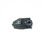 Introducing the ANOM Men's Black Cuff Leather Bracelet by Kaya Movement, which showcases a round, polished genuine Amethyst gemstone set within an intricately woven design. This bracelet features a wide band and exudes a rustic, handcrafted charm inspired by the artistry of the Kaya Movement.