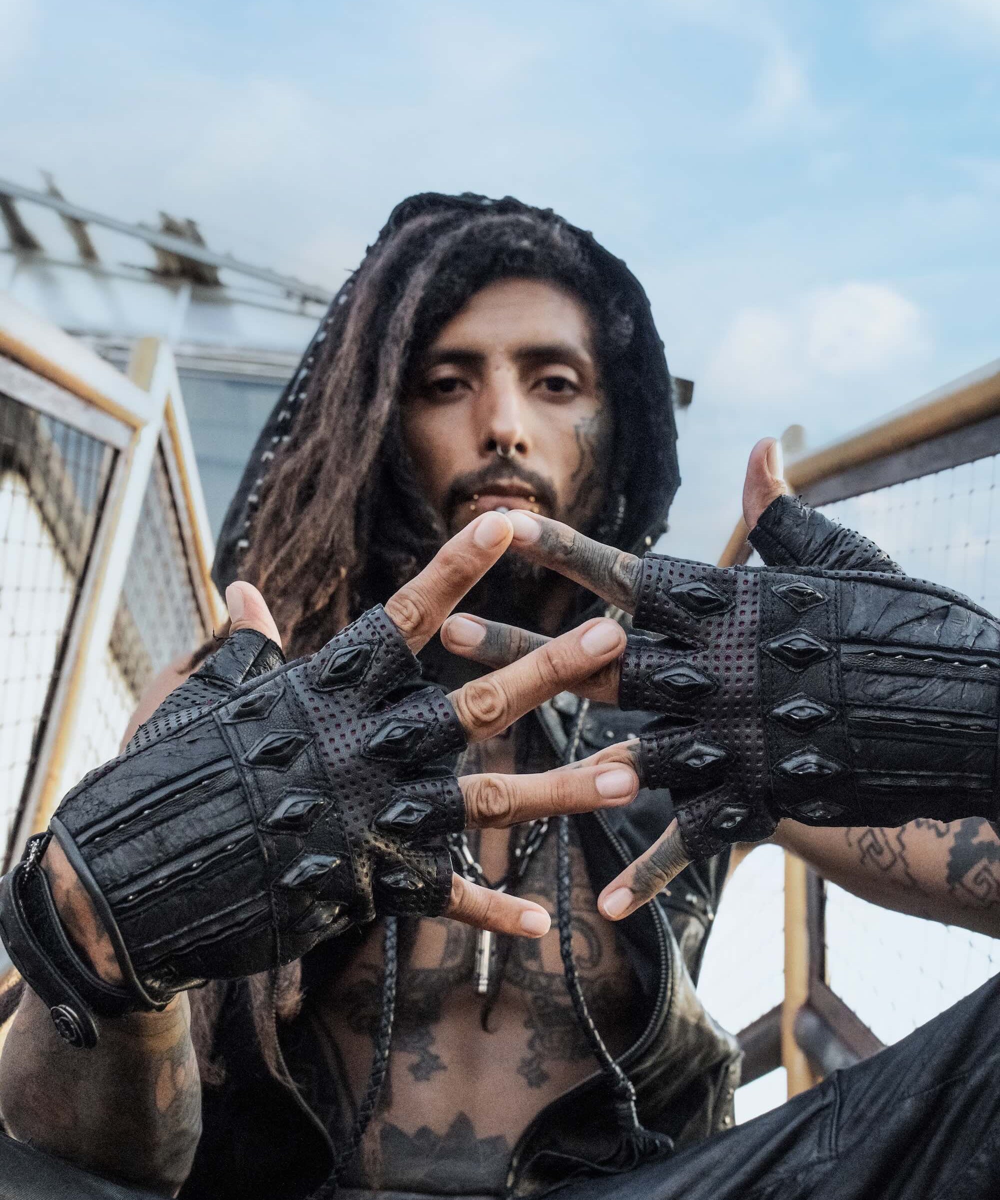 DZALA — black leather fingerless gloves with studs and red accents.