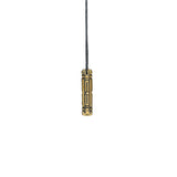 A closed brass Arcan Box pendant with intricate geometric engravings, hanging from a black cord against a white background.