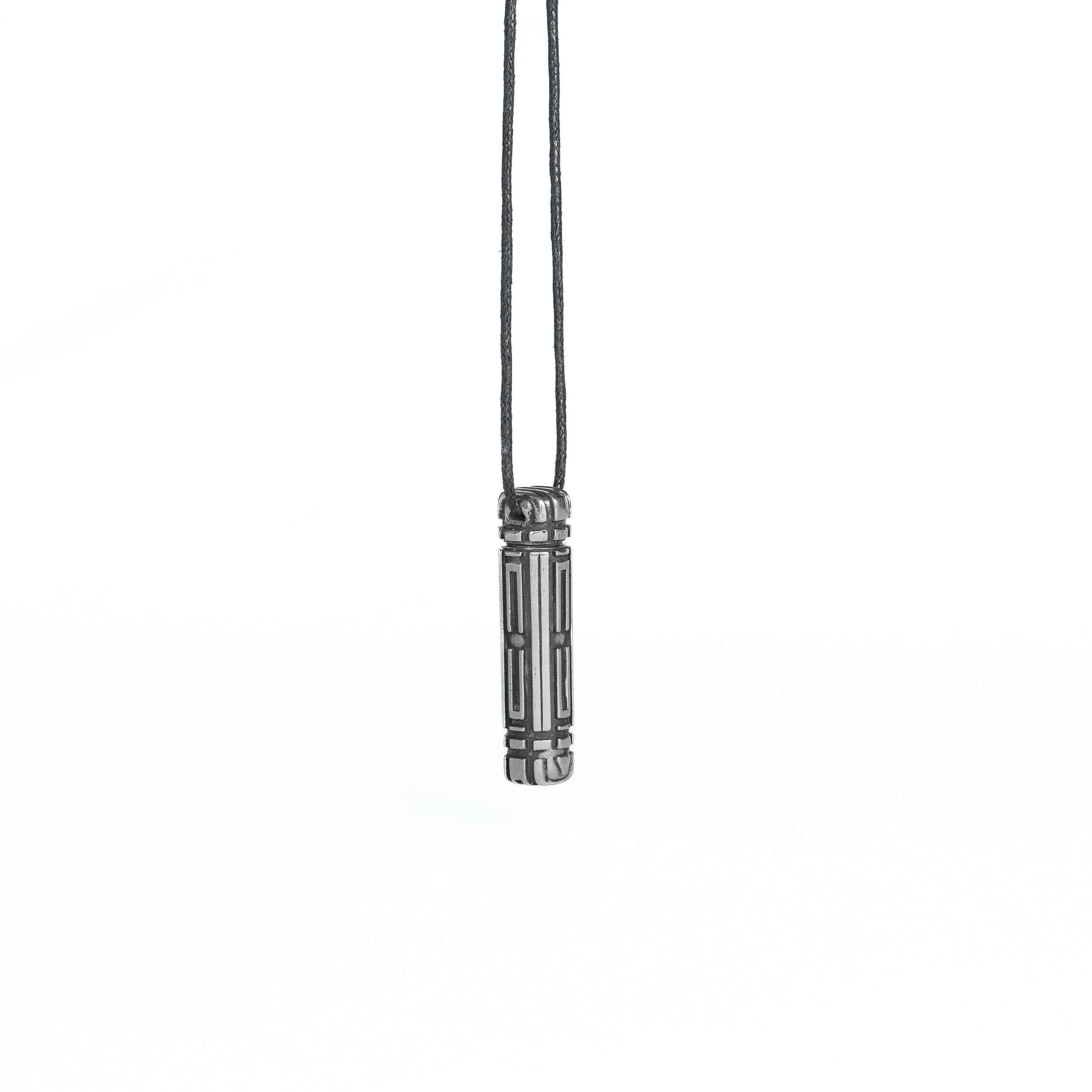 A side-angle view of the same futuristic pendant, showcasing its intricate linear patterns and metallic detailing, suspended from a cord.