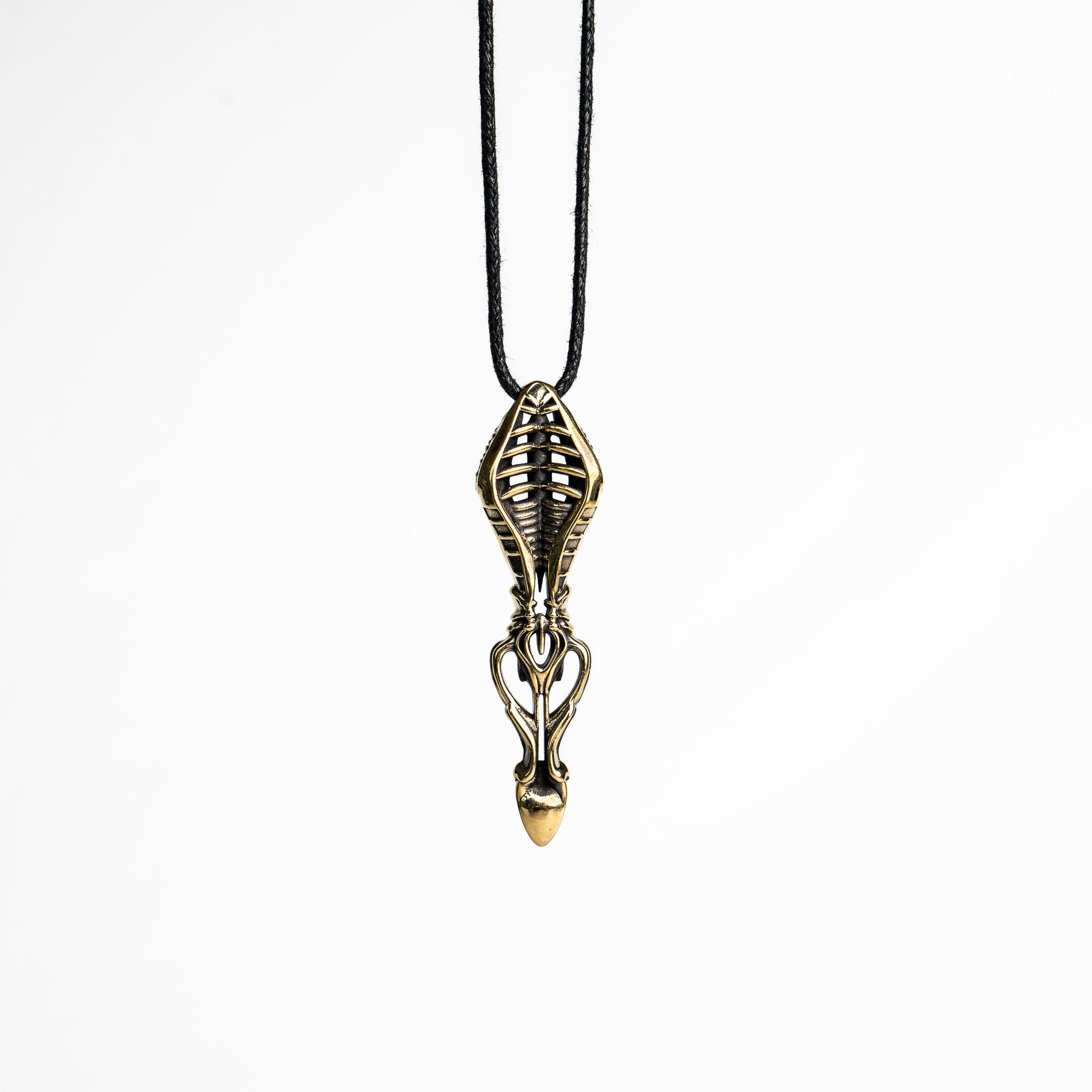 Intricate brass pendant with skeletal motifs and fluid lines, showcasing a sci-fi and dystopian design influence