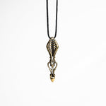 Intricate brass pendant with skeletal motifs and fluid lines, showcasing a sci-fi and dystopian design influence