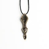 Long vertical brass spoon pendant with organic and mechanical elements, offering a blend of gothic and avant-garde style.
