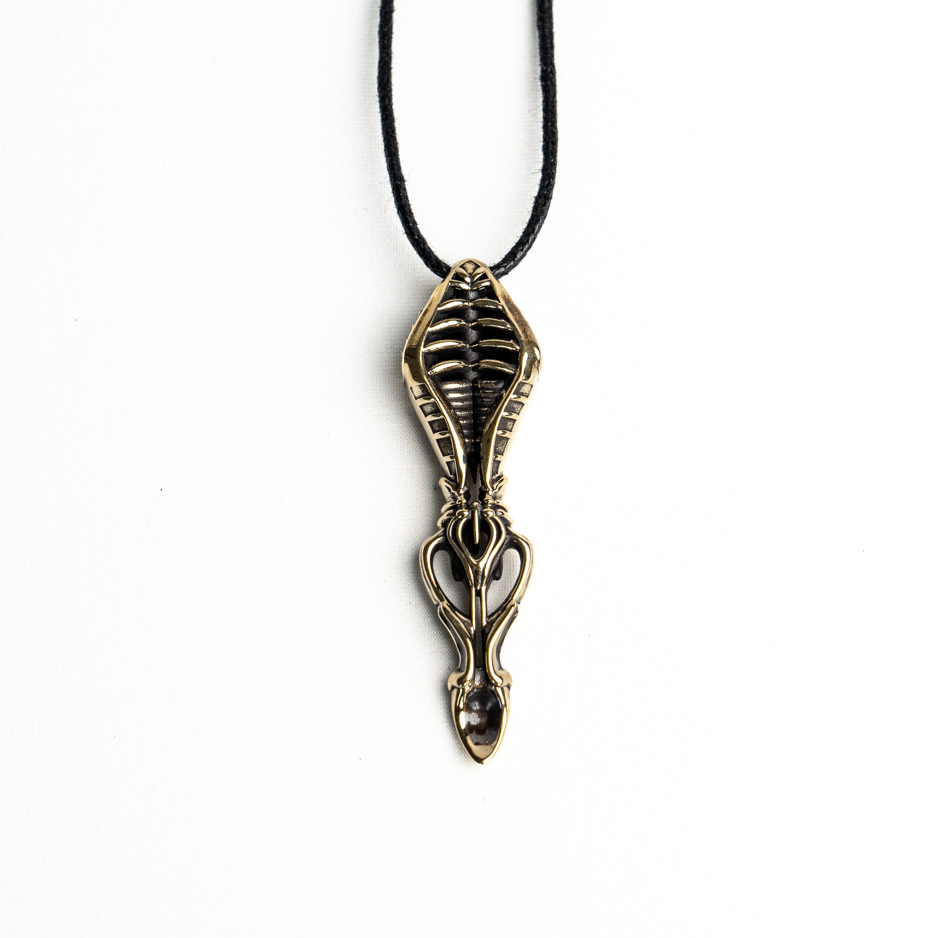 Long vertical brass spoon pendant with organic and mechanical elements, offering a blend of gothic and avant-garde style.