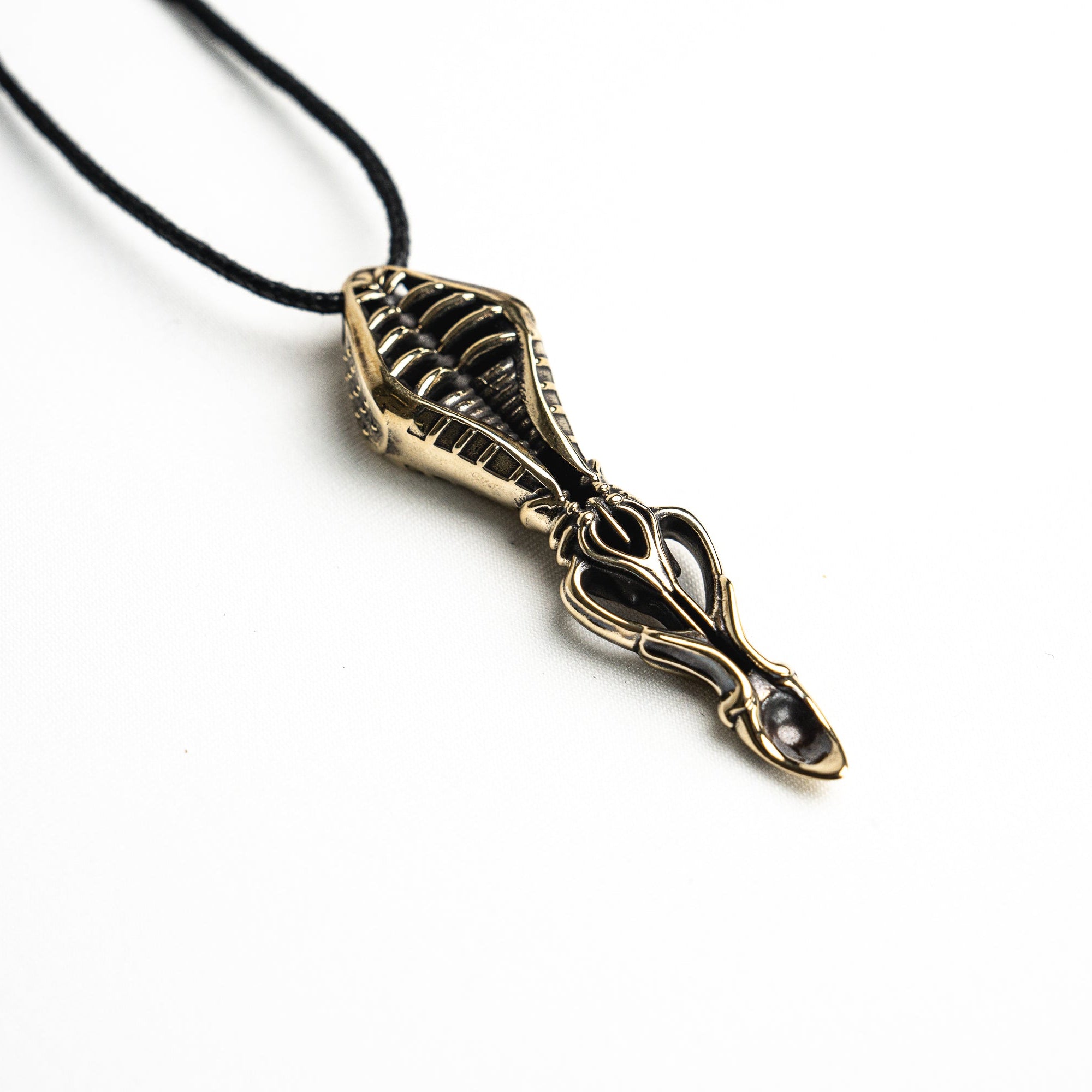 Close-up of the pendant’s tip, revealing the spoon-like scoop with a 6mm by 9mm dimension and surrealist design.