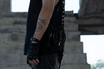 Close-up side view of a black leather holster bag with hand-carved dragon spine details, worn on the shoulder with studded straps.