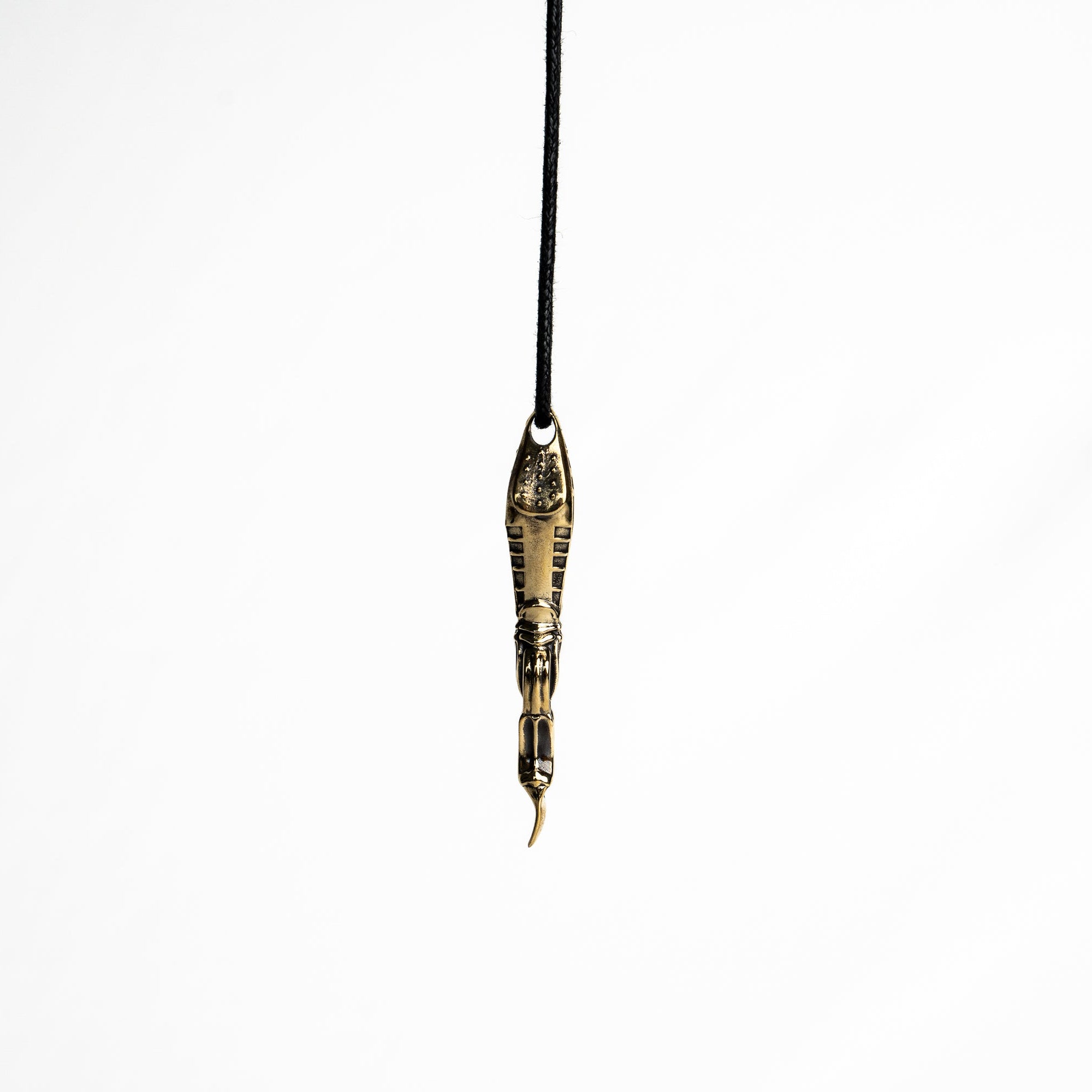 Side view of the brass spoon pendant, displaying the detailed craftsmanship and dark oxidized finish.