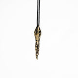 Sleek brass spoon pendant with biomechanical and cyberpunk design elements, hanging from a minimalist black cord.