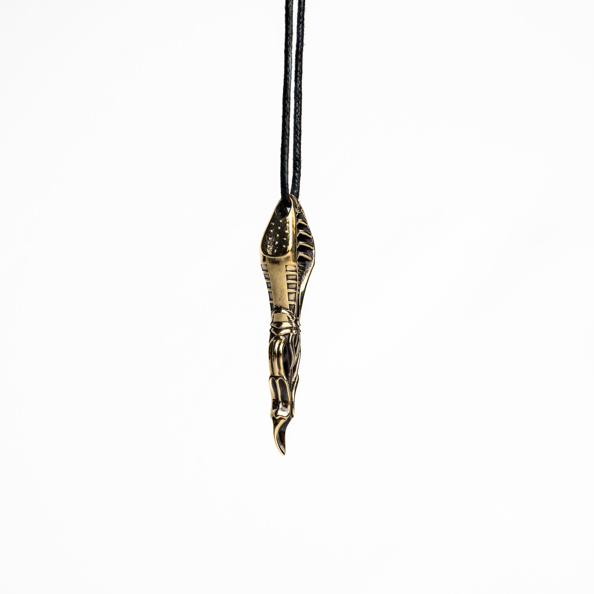 Sleek brass spoon pendant with biomechanical and cyberpunk design elements, hanging from a minimalist black cord.