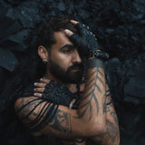 DZALA — black leather fingerless gloves with studs and red accents.