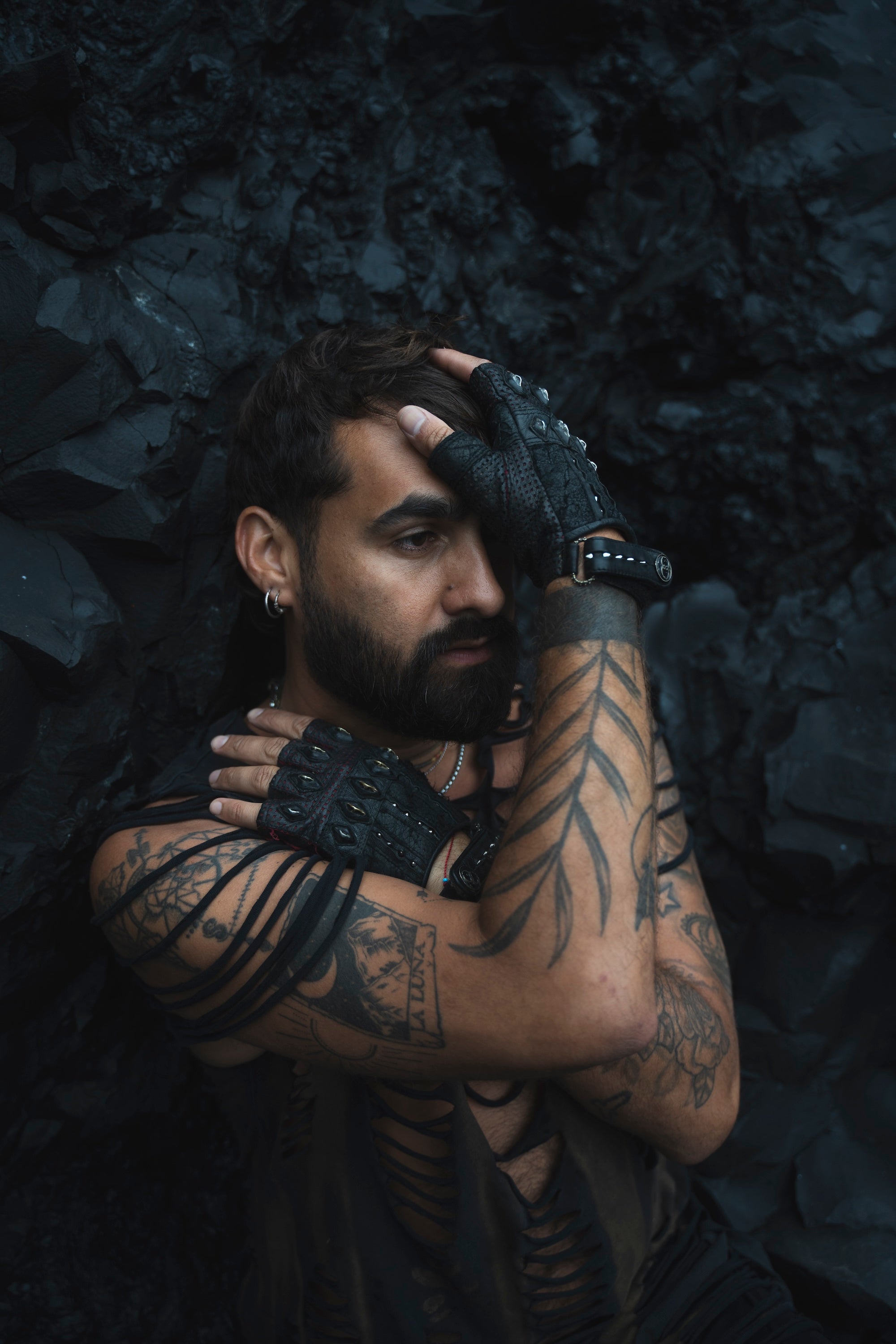 DZALA — black leather fingerless gloves with studs and red accents.