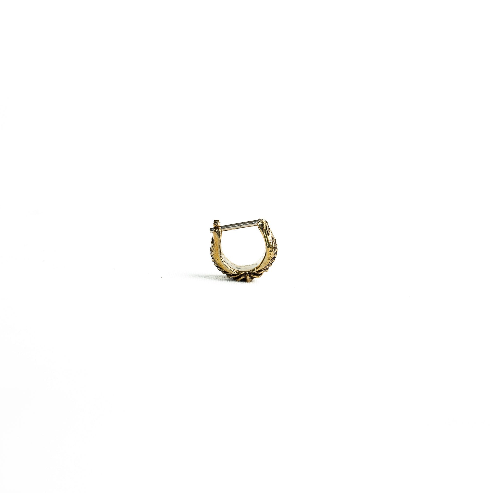 Front view of a single brass septum ring with an intricate handcrafted design, set against a white background.