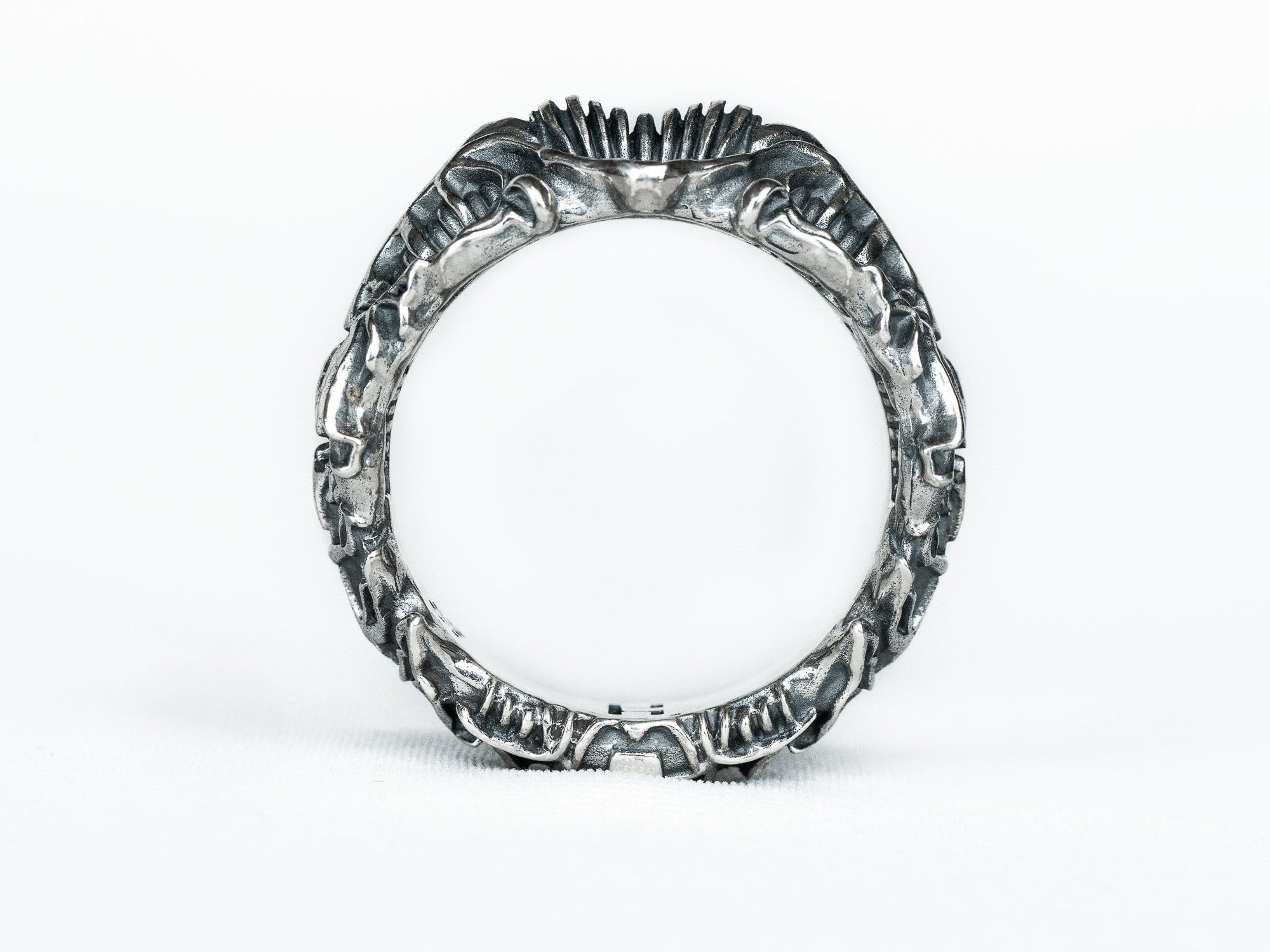 Side view of the BIOORGA silver ring showing the circular opening and sculpted alien-inspired relief.