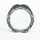 Side view of the BIOORGA silver ring showing the circular opening and sculpted alien-inspired relief.